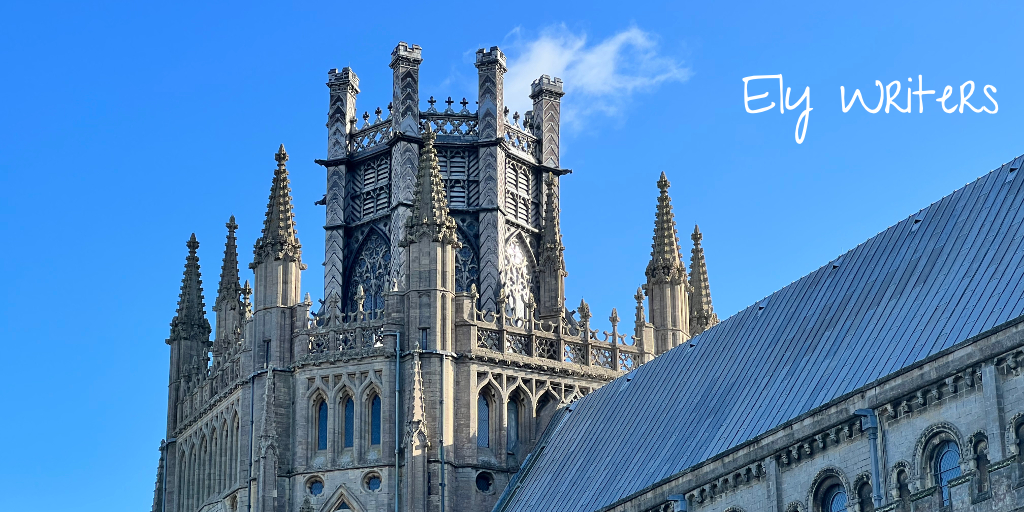 The Octagon Tower of Ely Cathedral set against a blue sky with a single white wispy cloud. The white text 'Ely Writers' in the Give You Glory font is to the right of the tower.